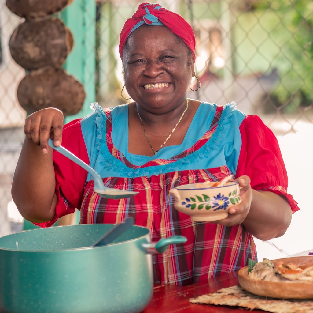 Woman preparing food in a community market setting.